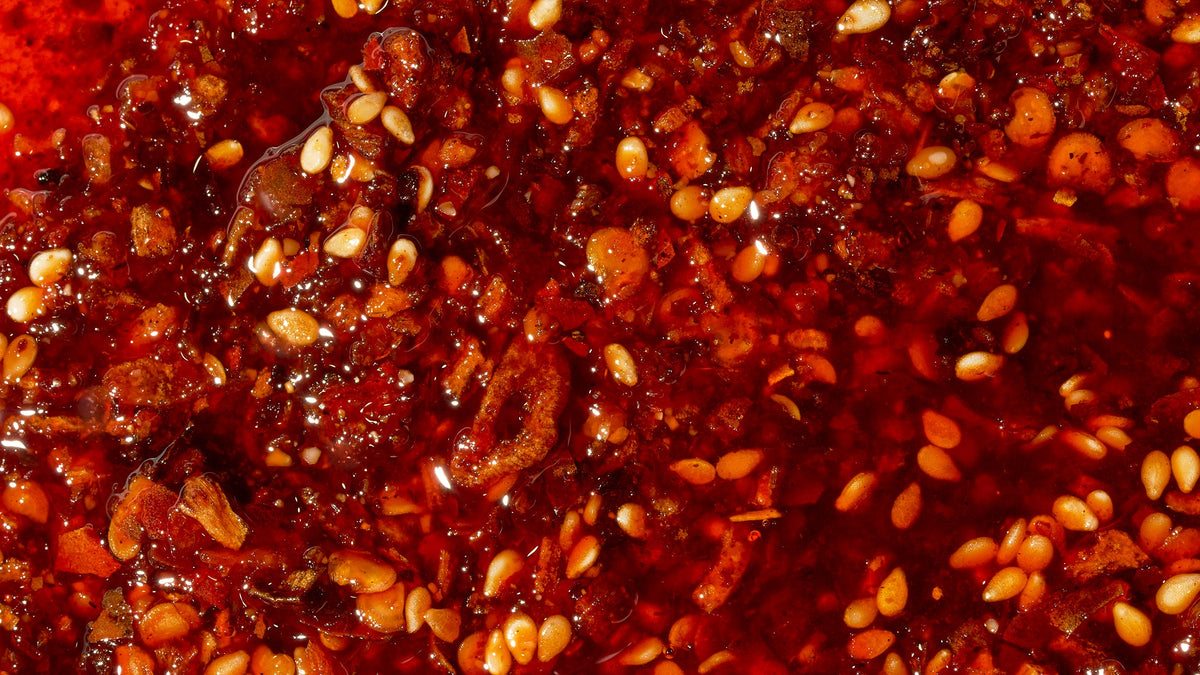 Close-up of Tapatio Chili Crisp with chili flakes and sesame