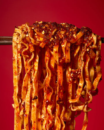 Noodles lifted from a bowl with Tapatio Chili Crisp