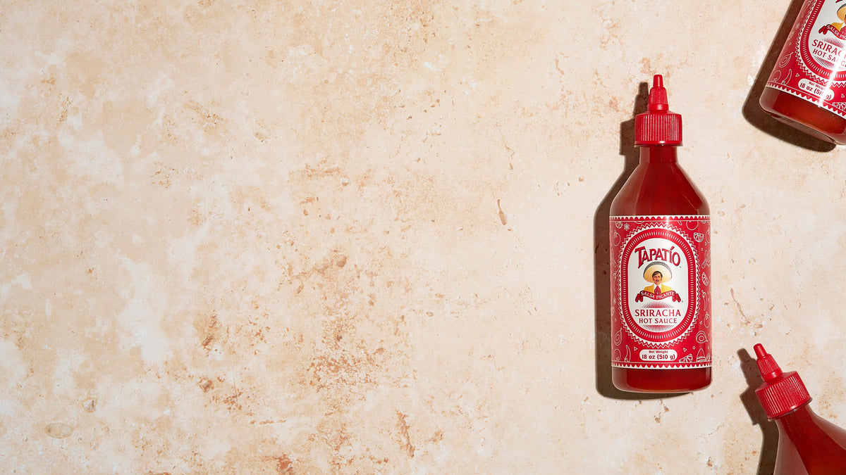 Tapatio Sriracha Hot Sauce bottles on a stone background